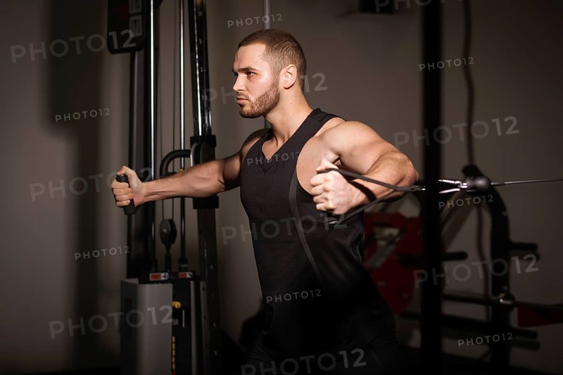 Sporty sexy men with great abdominal muscles in black sportswear working out in the gym