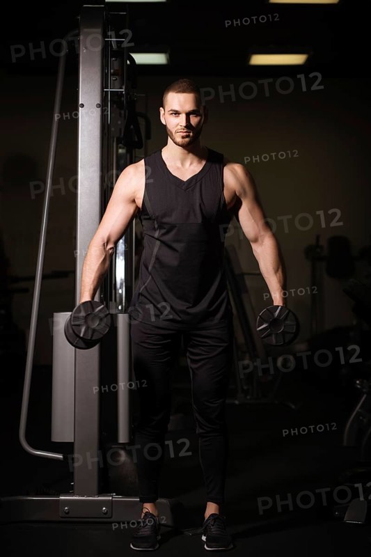 Sporty sexy men with great abdominal muscles in black sportswear working out in the gym