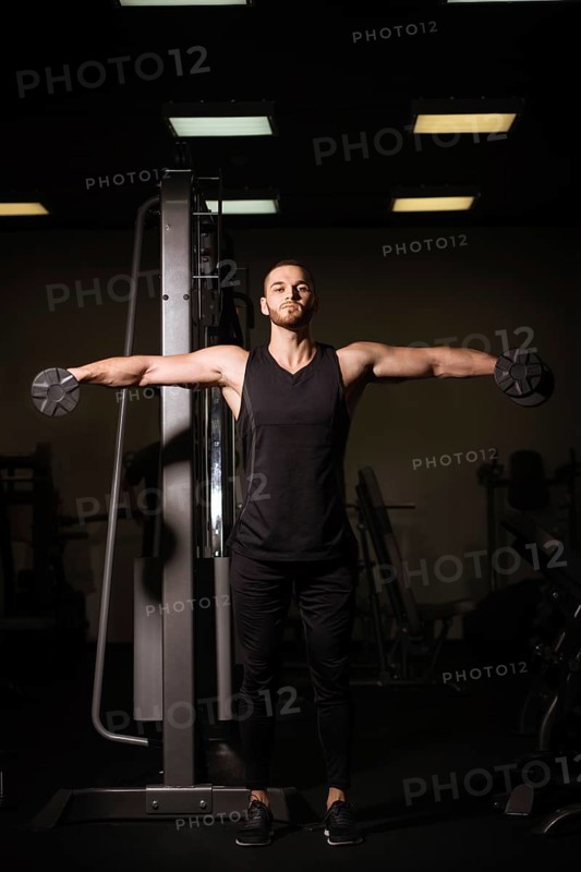 Sporty sexy men with great abdominal muscles in black sportswear working out in the gym