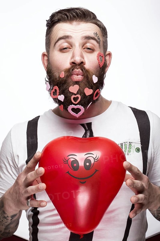 Funny bearded man with hearts Valentine's Day. Portrait shot in studio