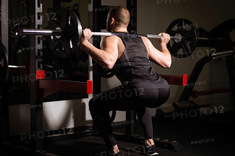 Sporty sexy men with great abdominal muscles in black sportswear working out in the gym