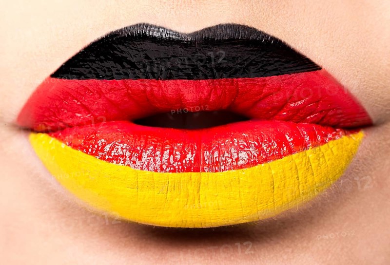 Female lips close up with a picture of the flag of Germany. black
