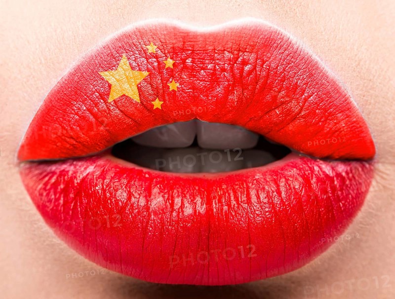 Female lips close up with a picture of the flag of China. Red color