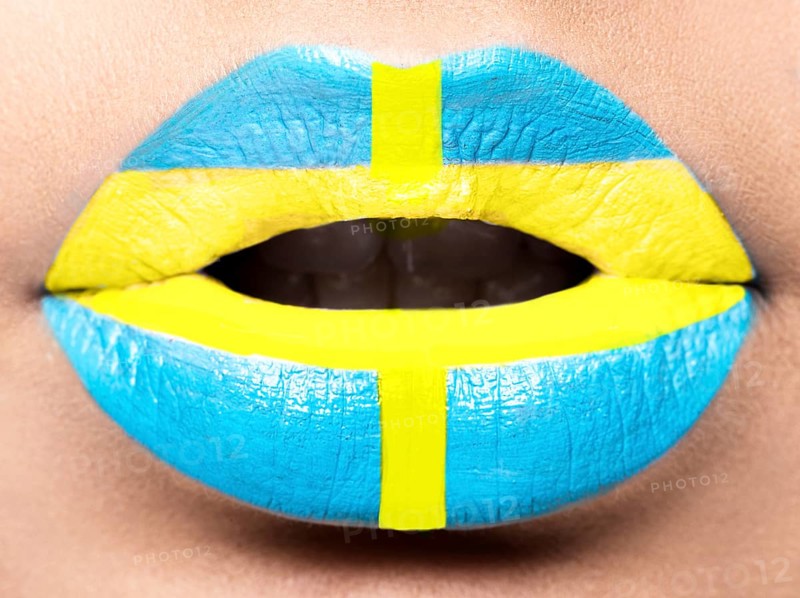 Female lips close up with a picture of the flag of Sweden. blue