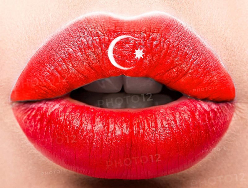 Female lips close up with a picture of the flag of Turkey. Red and white month