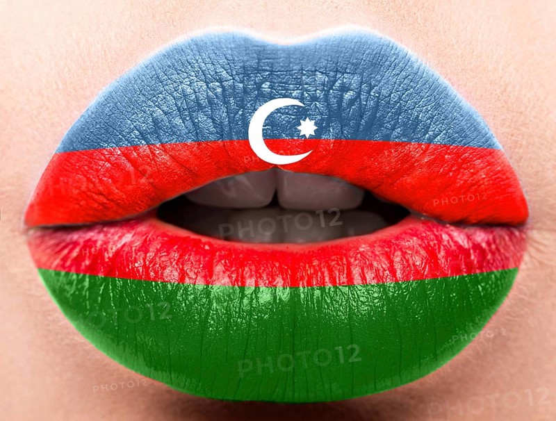 Female lips close up with a picture of the flag of Azerbaijan. Blue