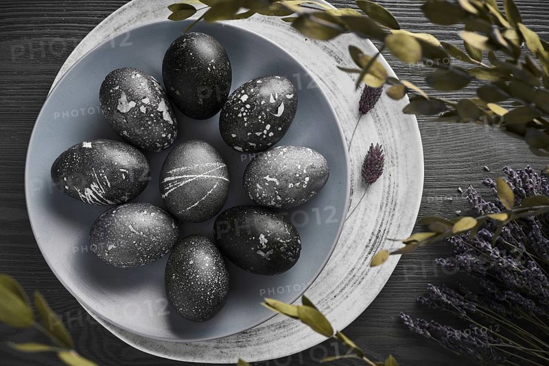 Black painted eggs for Easter on a blue plate