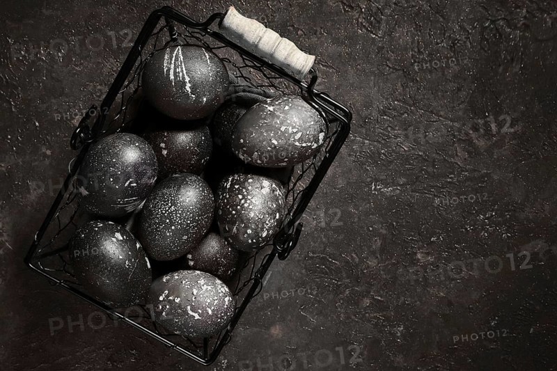Black painted eggs for Easter in a basket