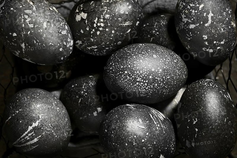 Black painted eggs for Easter in a basket