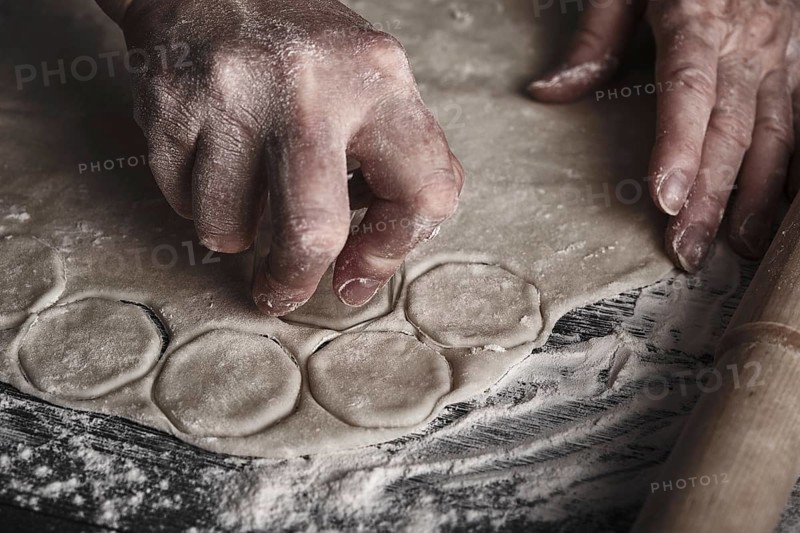 Cooking dough by elderly woman cook hands for homemade pastry dumplings on table background