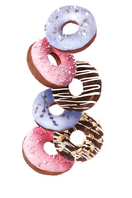 Sweet multicolored donuts on a white background in levitation