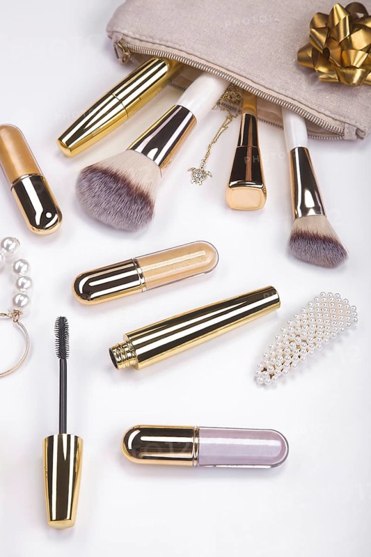 Set of brushes and cosmetic products in a cosmetic bag on a white background