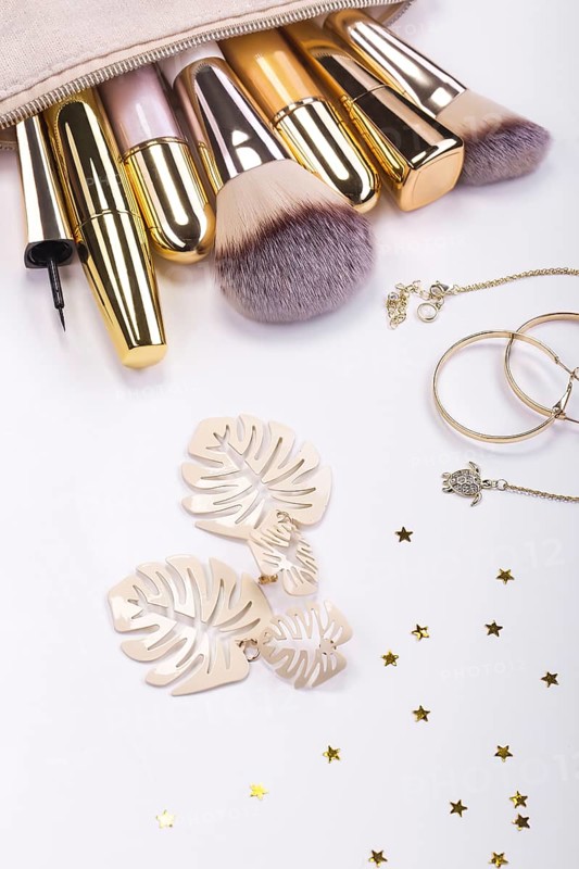 Set of brushes and cosmetic products in a cosmetic bag on a white background