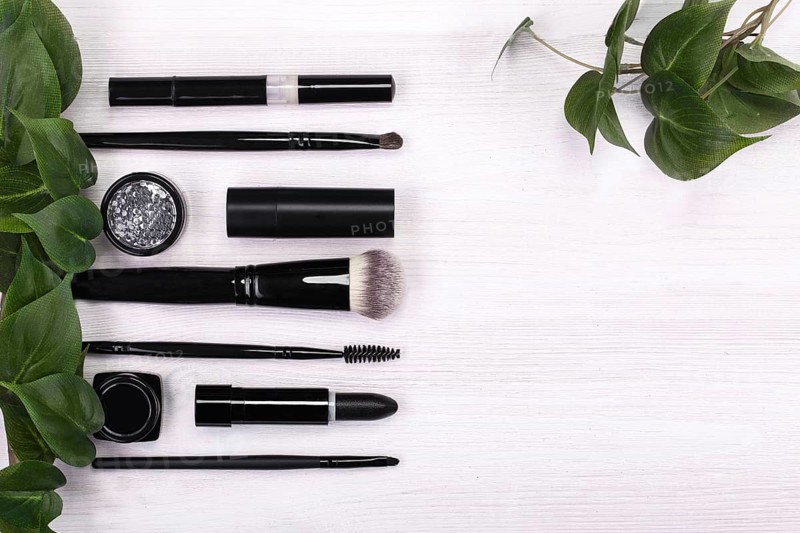 Set of brushes and cosmetic products in a cosmetic bag on a white background