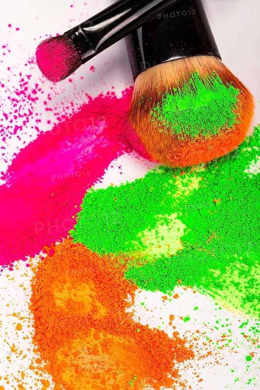 Cheek brush with neon cosmetic powder colorful pile and isolated on white background