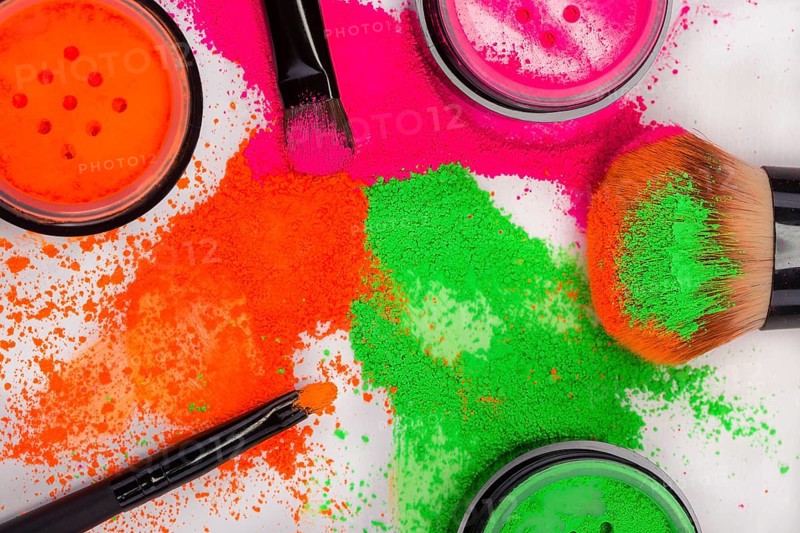 Cheek brush with neon cosmetic powder colorful pile and isolated on white background
