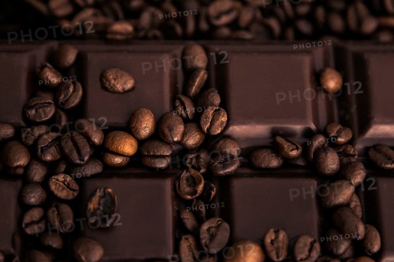 Roasted coffee beans and chocolate bar close-up