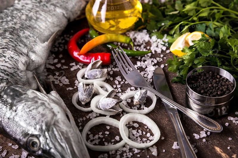 Delicious fresh fish on dark vintage background. Fish with aromatic herbs
