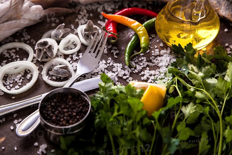 Delicious fresh fish on dark vintage background. Fish with aromatic herbs