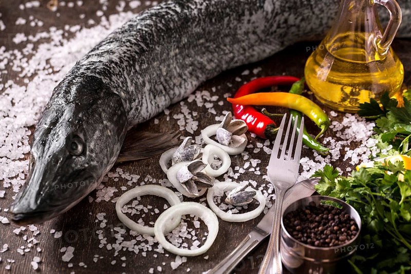 Delicious fresh fish on dark vintage background. Fish with aromatic herbs