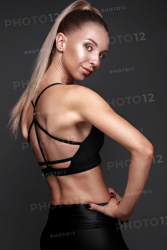 Sports girl with pumped muscles in a tracksuit