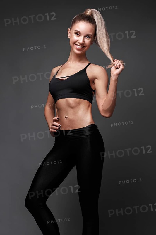 Sports girl with pumped muscles in a tracksuit