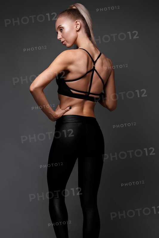 Sports girl with pumped muscles in a tracksuit