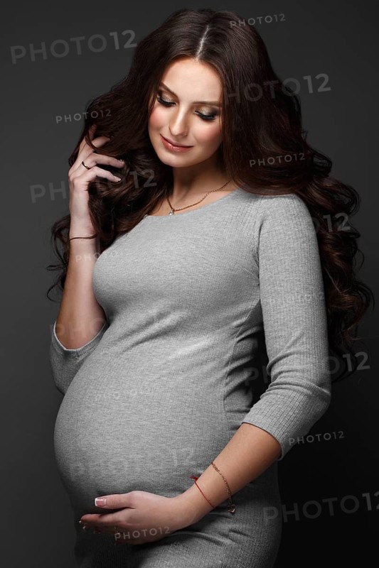 Beautiful pregnant woman in a gray dress