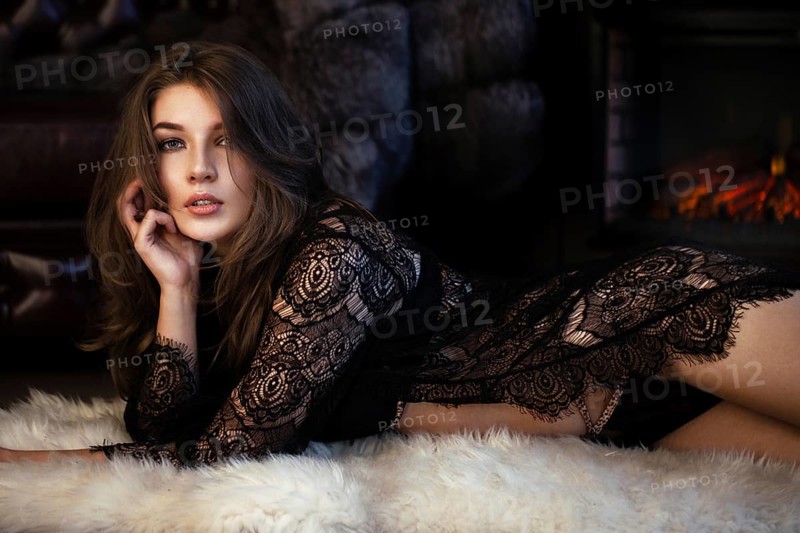 Beautiful sexy long-haired woman in black lingerie posing in the interior. The beauty of the face and body. Photos shot in a studio interior