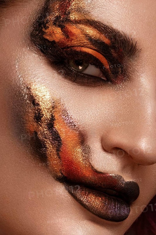 Portrait of a beautiful woman with creative fire art make-up on her face