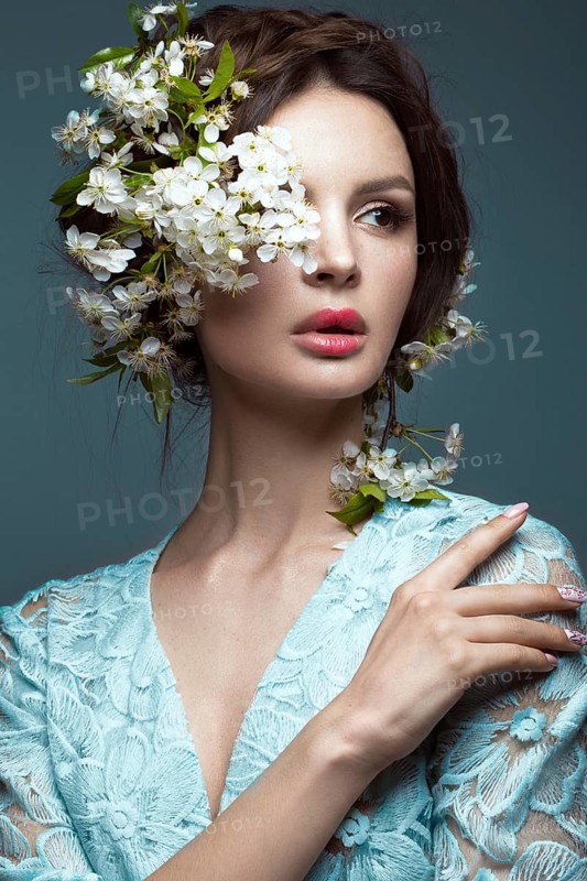 Beautiful brunette girl in blue dress with a gentle romantic make-up