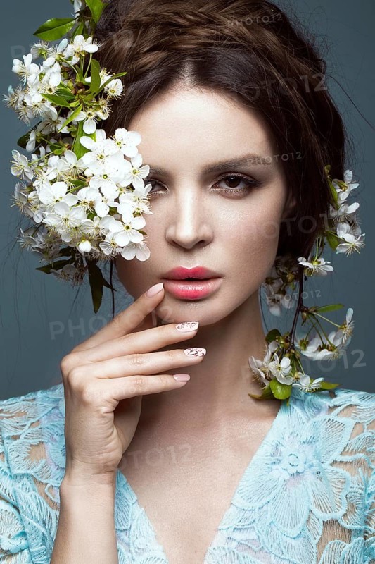 Beautiful brunette girl in blue dress with a gentle romantic make-up