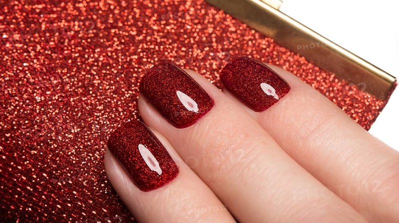 Bright festive red manicure on female hands. Nails design