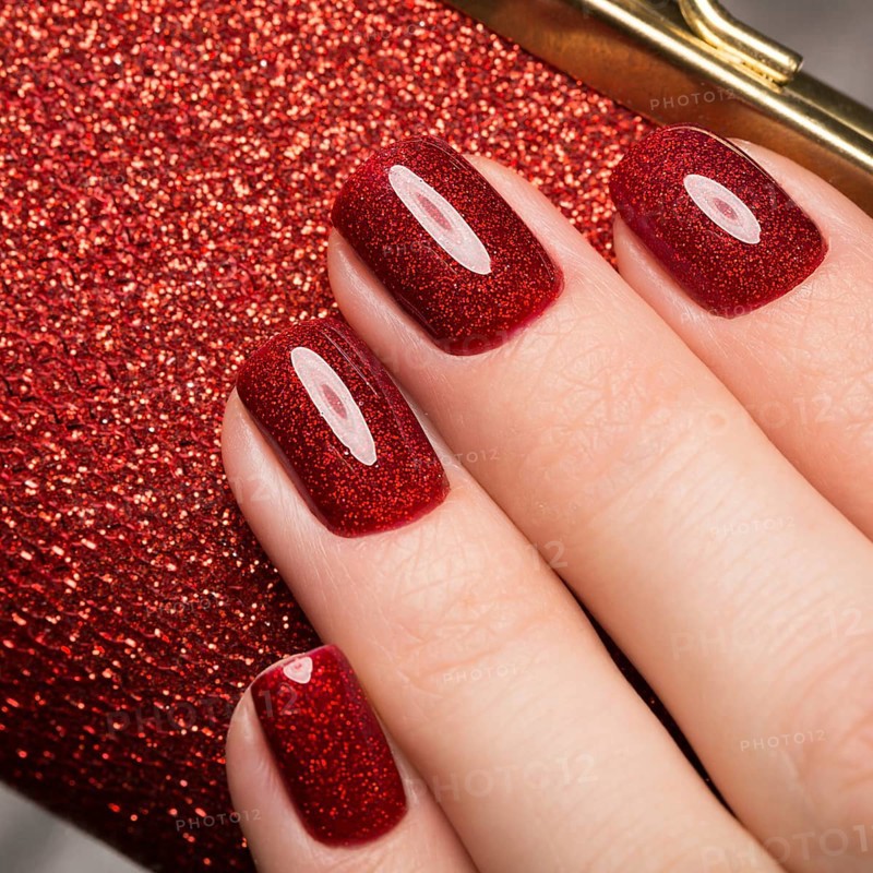 Bright festive red manicure on female hands. Nails design