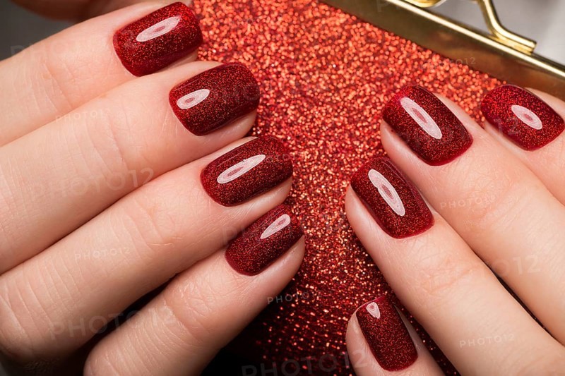Bright festive red manicure on female hands. Nails design