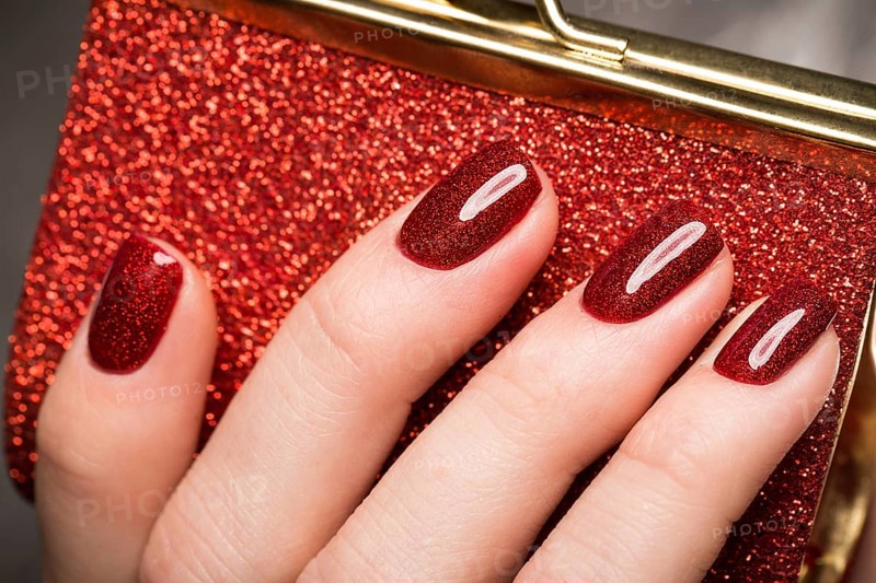 Bright festive red manicure on female hands. Nails design