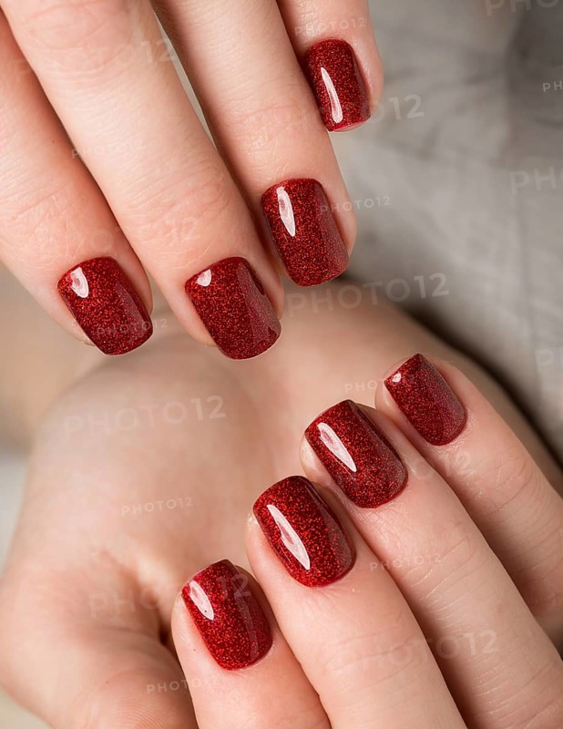 Bright festive red manicure on female hands. Nails design