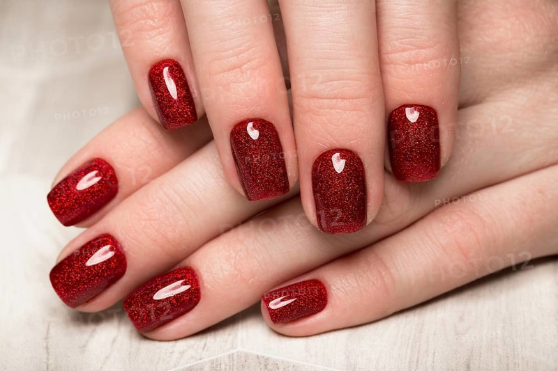 Bright festive red manicure on female hands. Nails design