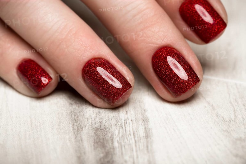Bright festive red manicure on female hands. Nails design