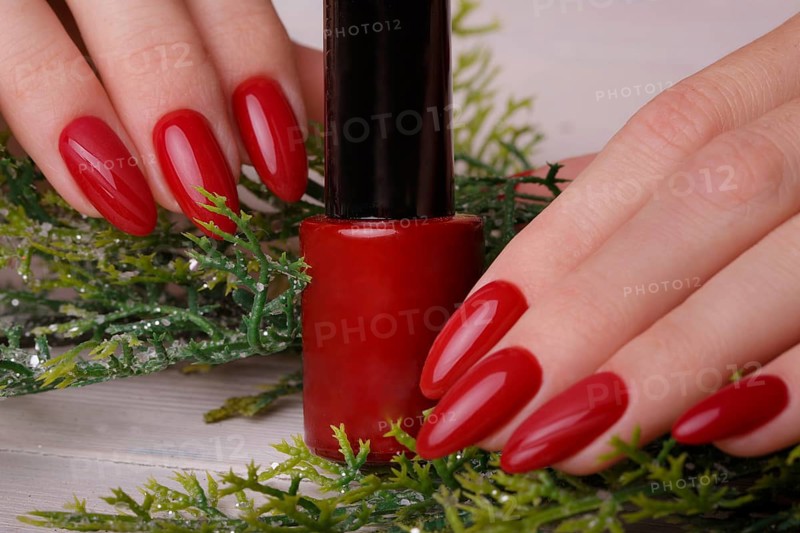 Bright festive red manicure on female hands. Nails design