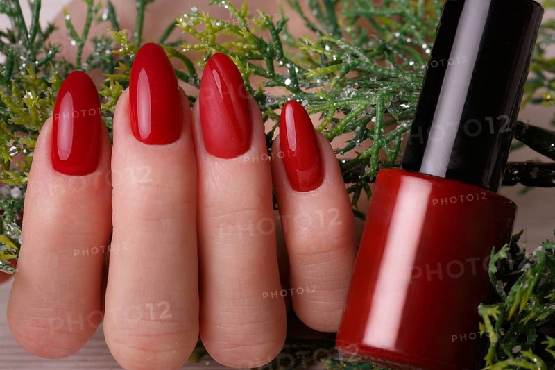Bright festive red manicure on female hands. Nails design