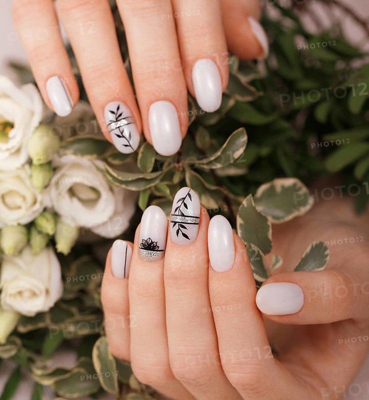 Gentle neat manicure on female hands on a background of flowers. Nail design