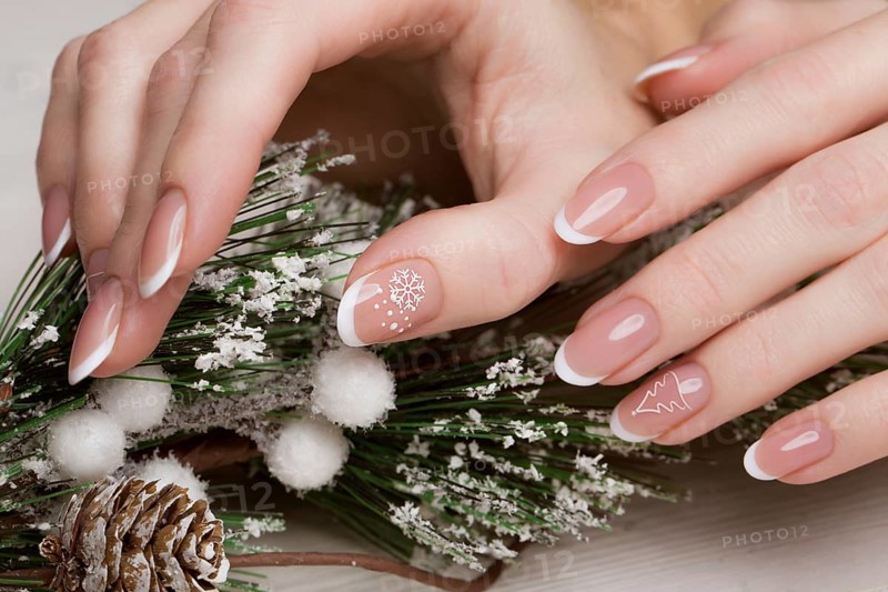 Snow White manicure on female hands. Winter nail design. Picture taken in the studio on a background of wool