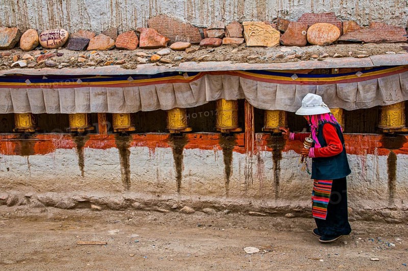 Old woman turning the prayer wheels in the kingdom of Guge