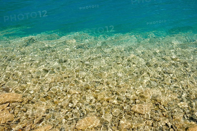 Fascinating play of colours and shapes of the clear water of Lake Walen at the edge of the shore