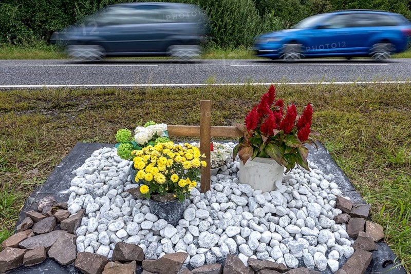 Memorial with cross for victims of road accident on country road