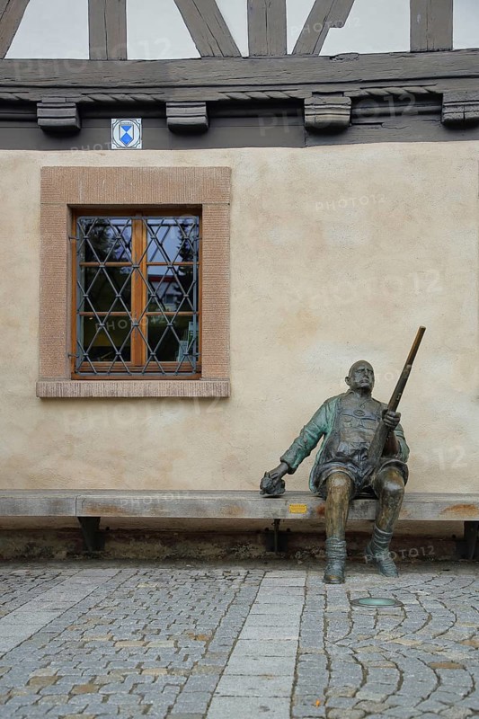 Sculpture Man sitting with rifle in front of half-timbered house Weapons Museum and window