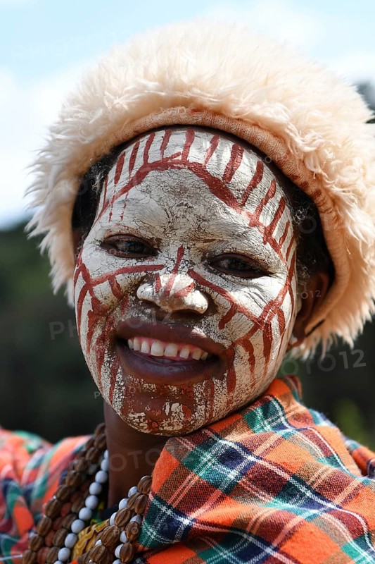 Kikuyu woman with face paint poses for photographers at Nyahururu Falls