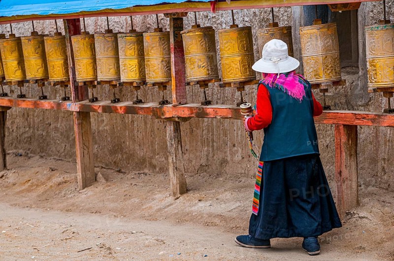 Old woman turning the prayer wheels in the kingdom of Guge