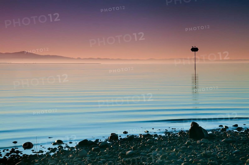 Sea mark at sunset on Lake Constance near Lochau